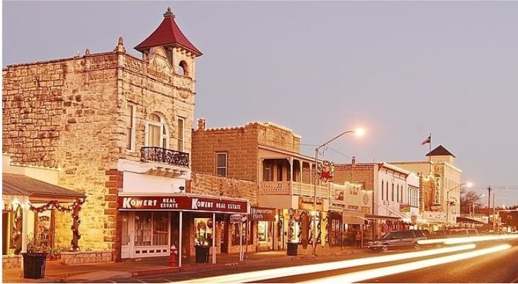Historic stone storefronts along Main Street in Fredericksburg, Texas glowing at golden hour