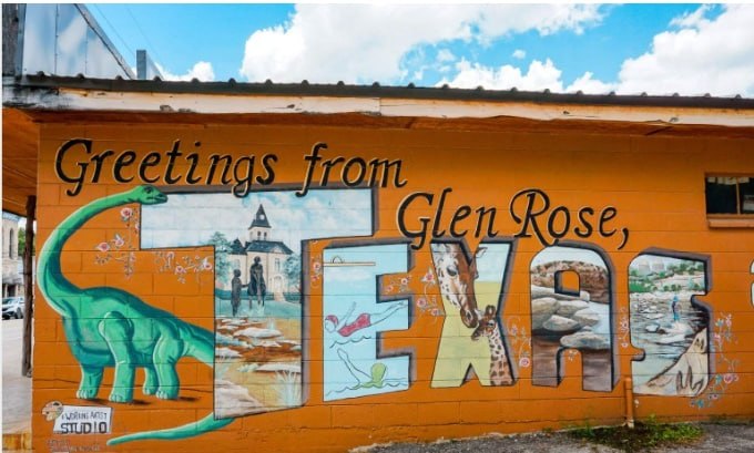 Colorful Greetings from Glen Rose, Texas mural featuring a dinosaur, the Paluxy Riverbed, and local landmarks