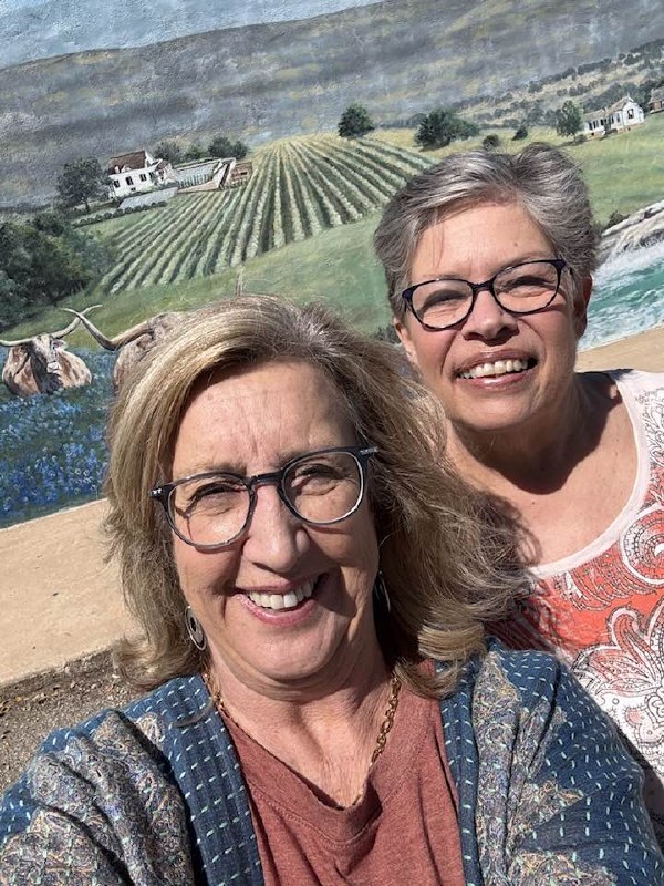 Diane and Karen in front of a Hill Country mural in Johnson City
