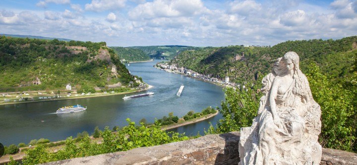 Panoramic view of the Rhine River valley with statue and river cruise ship